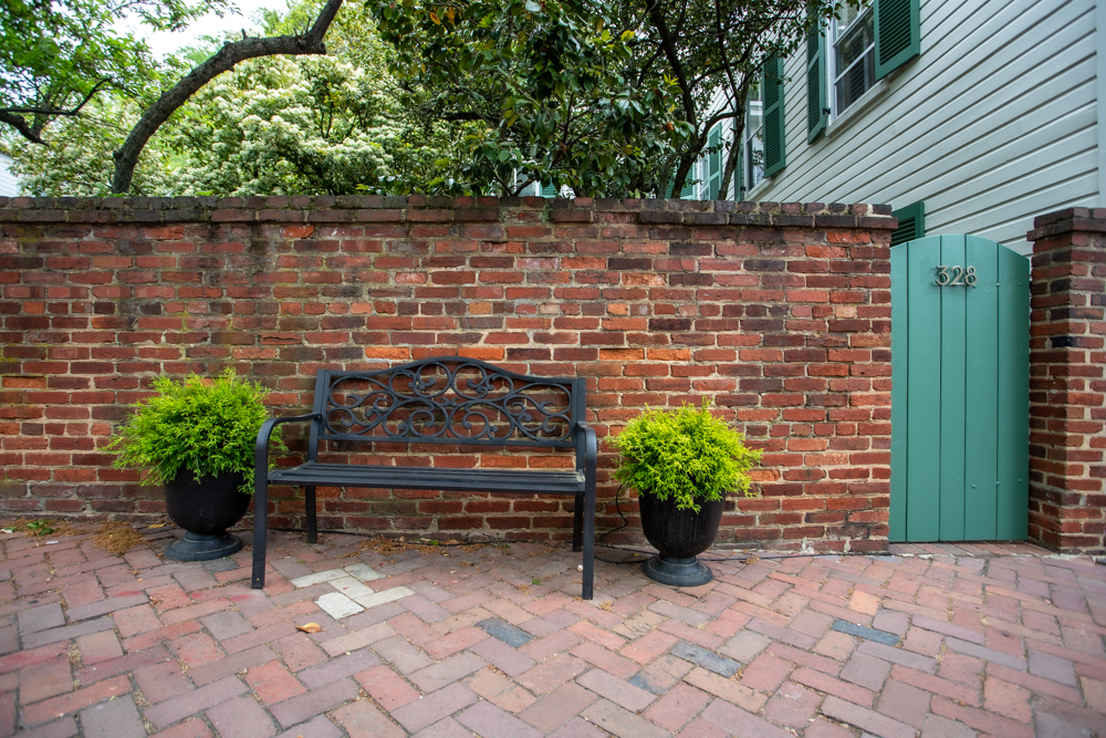 Bench beside brick wall in Old Town Alexandria Courtyard