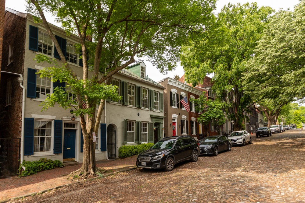 Cars parked beside row houses with trees overhead in Old Town Alexandria. Cooling historic homes in Old Town Alexandria